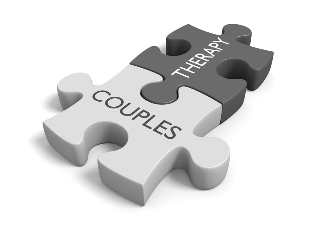 Two interlocking puzzle pieces labeled "COUPLES" and "THERAPY," symbolizing the connection between relationship therapy and couples.